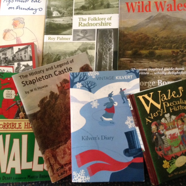 A selection of books about Welsh history, folklore, and landscapes, stacked on a surface.