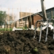 a garden fork stuck in a pile of dirt